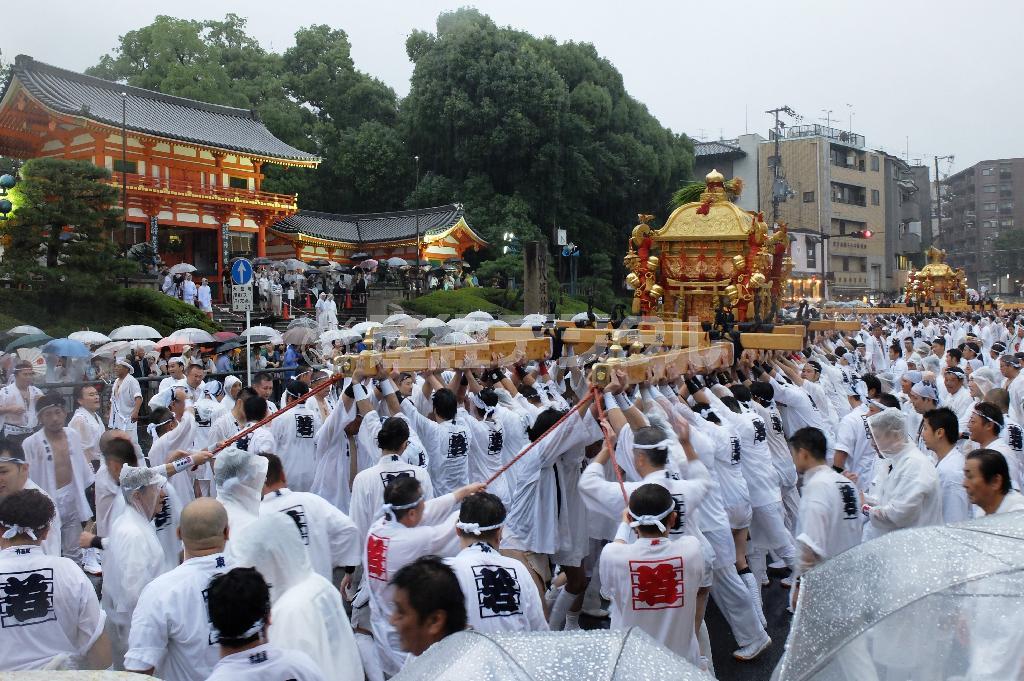 祇園祭の神幸祭で激しい雨が絶え間なく降る中、「ホイットー」のかけ声とともにご祭神をのせた神輿を力強く差し上げる担ぎ手たち＝２０１５年７月１７日午後６時３０分、京都市東山区の八坂神社石段下（田中幸美撮影）