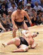 すくい投げで照ノ富士（手前）を転がした鶴竜（かくりゅう）＝２０１５年７月２３日、愛知県名古屋市中区の愛知県体育館（森本幸一撮影）