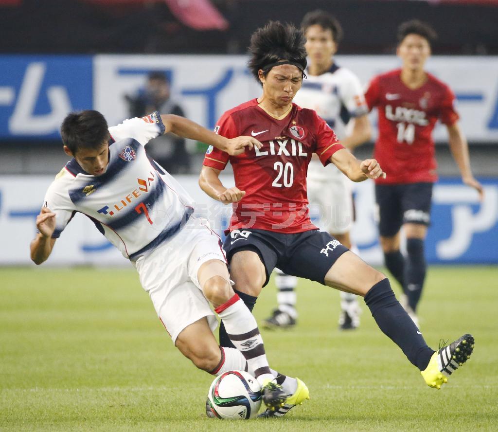 前半、ＦＣ東京・米本拓司（たくじ、左）と競り合う鹿島・柴崎岳（がく、中央）＝２０１５年７月２５日、茨城県鹿嶋市のカシマサッカースタジアム（共同）