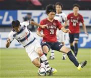 前半、ＦＣ東京・米本拓司（たくじ、左）と競り合う鹿島・柴崎岳（がく、中央）＝２０１５年７月２５日、茨城県鹿嶋市のカシマサッカースタジアム（共同）