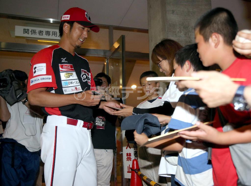 試合終了後残ったファンにサインする高知の藤川球児（きゅうじ）投手（左）。その加入で独立リーグは大きく盛り上がっている＝２０１５年７月１２日、高知県高知市の高知球場（中島信生撮影）