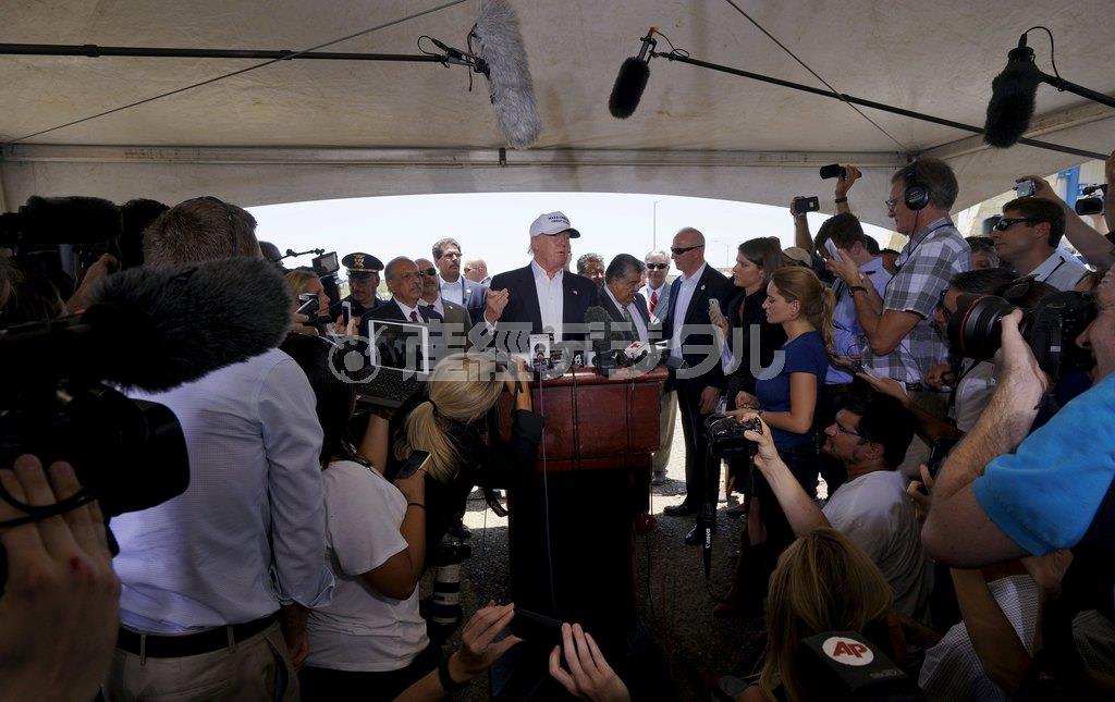 ７月２３日、米テキサス州南部のメキシコとの国境の町、ラレードを視察した後に記者会見に臨むドナルド・トランプ氏（中央）。「移民流入を防ぐため、国境地帯には『万里の長城』が必要で、建設費用はメキシコ政府に払わせる」などと、再び過激な持論を展開した＝２０１５年（ロイター）
