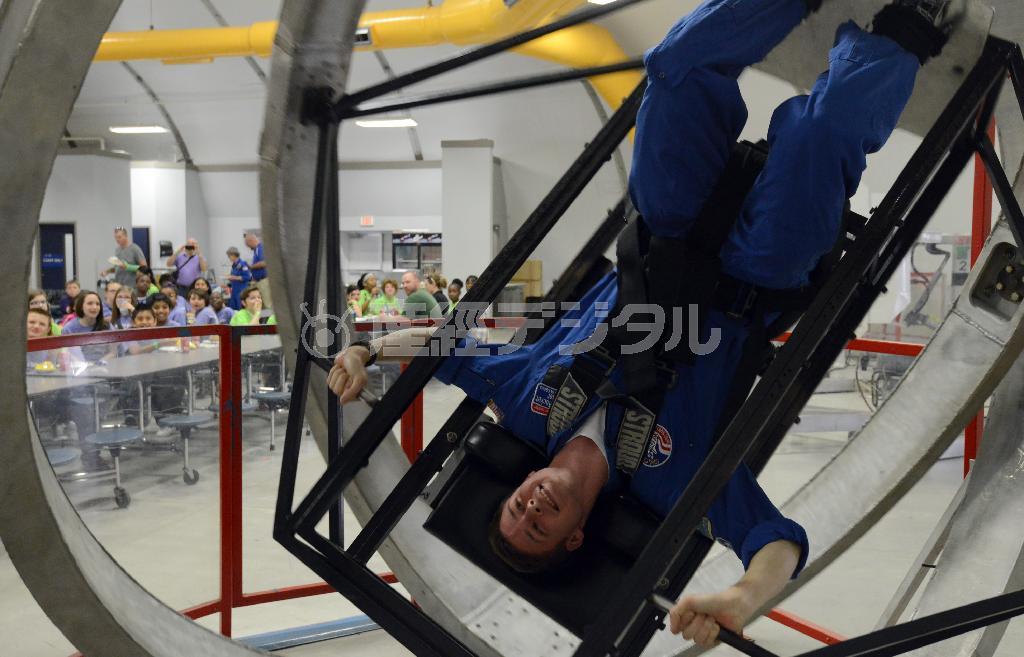 打ち上げ時にかかる重力を体験できるシミュレーター。笑顔を絶やさないトレーナーに、昼食中の子供たちも興味津々＝２０１５年３月２６日、米アラバマ州ハンツビルのアメリカ宇宙ロケットセンター（川口良介撮影）