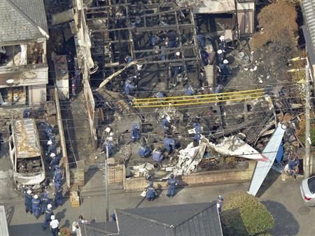 小型プロペラ機の墜落現場を調べる捜査員＝２０１５年７月２８日午後、東京都調布市（共同通信社ヘリから撮影）
