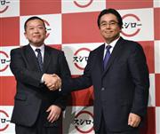 あきんどスシローの水留浩一社長（右）は、前社長の豊崎賢一氏と握手を交わし、事業拡大を誓った＝２０１５年１月、東京都港区