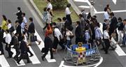 横断歩道を行き交う人々。最低賃金の引き上げ幅は過去最大となった＝２０１５年６月８日、東京都内（ロイター）