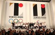 大会組織委と東京都が発表した東京五輪のエンブレム前で記念撮影する関係者ら＝２０１５年７月２４日午後、東京都新宿区（古厩正樹撮影）