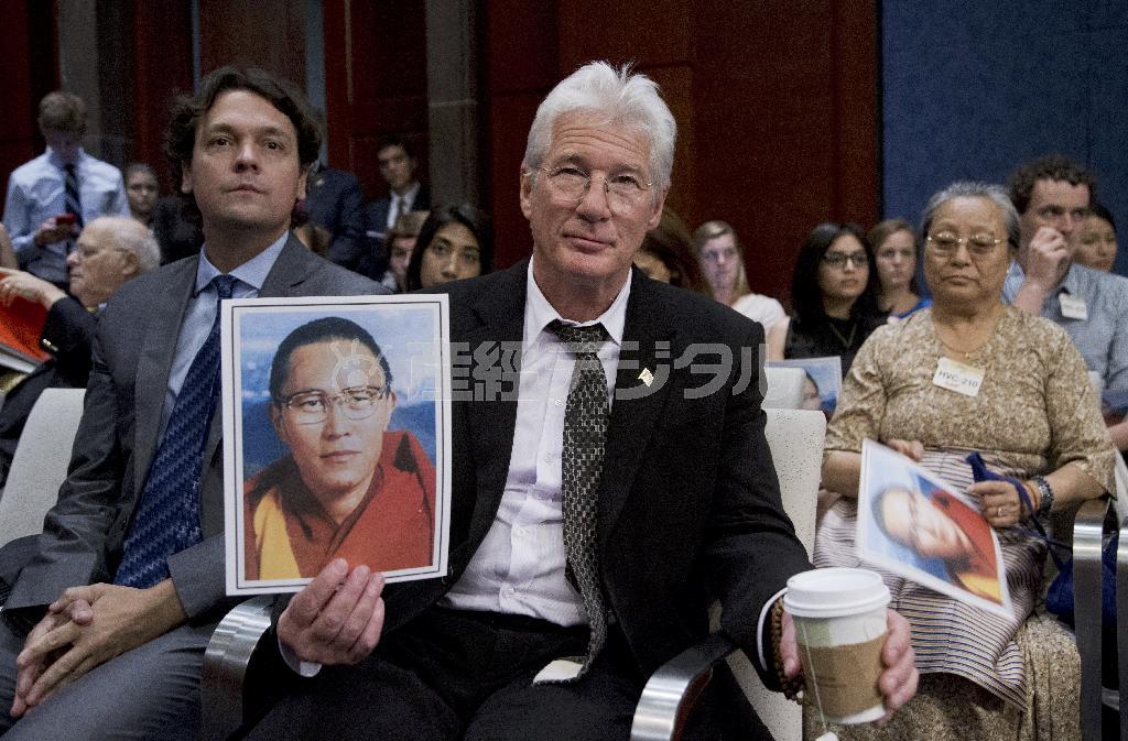 米下院の公聴会で、中国で収監中に死亡したチベット仏教僧侶の遺影を掲げるリチャード・ギア氏（中央）＝２０１５年７月１４日、米国・首都ワシントン（ＡＰ）