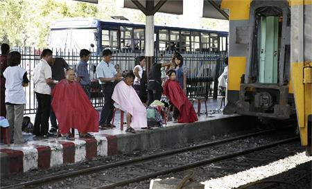 タイ国鉄バンコク駅（ファランボーン駅）１２番線ホームでは、床屋さんが営業している。鏡もない素朴な床屋さんだ。切符を改札口で見せなくても駅のホームに入れるので散髪だけに来る人もいる（酒井久美子さん撮影）