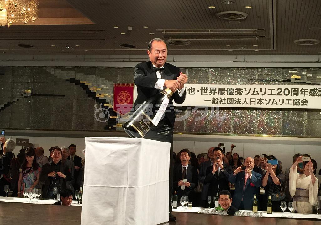 バルタザール（１２リットルの容量）のシャンパンを抜栓する田崎真也氏＝２０１５年７月３０日、東京都千代田区（青木冨美子さん撮影）