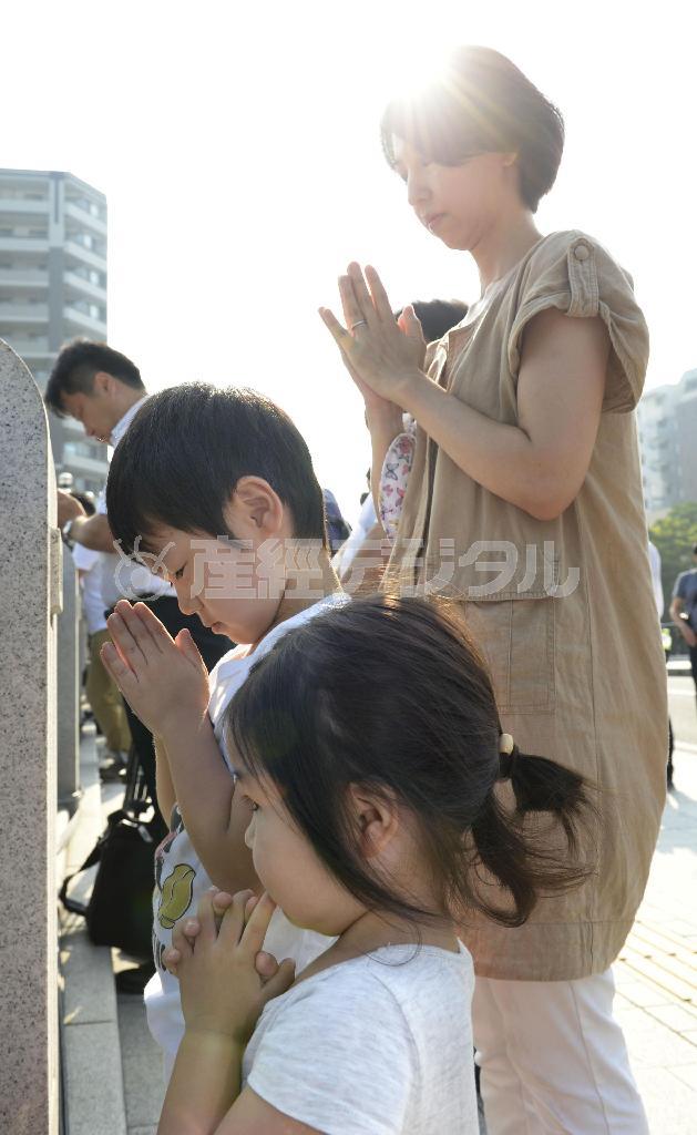 原爆投下時刻に合わせ、黙祷（もくとう）する親子＝２０１５年８月６日午前８時１５分、広島県広島市中区中島町の平和記念公園（共同）