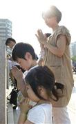 原爆投下時刻に合わせ、黙祷（もくとう）する親子＝２０１５年８月６日午前８時１５分、広島県広島市中区中島町の平和記念公園（共同）