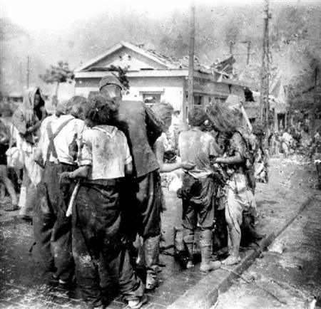 被爆から約３時間後、爆心地から約２．３キロの広島市内の御幸橋（みゆきばし）西詰で撮影された写真。竹内節子さんと見られる人物（もんぺにサスペンダー姿）が写っている＝１９４５年８月６日（松重美人氏撮影、中国新聞社所蔵、共同）