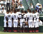 試合前、ベンチ前で黙祷（もくとう）する創成館の選手たち＝２０１５年８月９日、兵庫県西宮市・甲子園球場（共同）