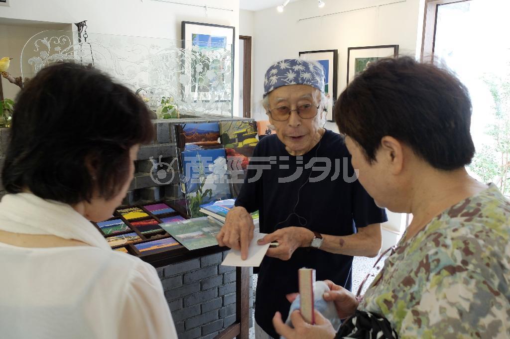 来館者に自身の作品の解説をする内田正泰さん。運がいいと内田さん本人に合うことができるかもしれない＝２０１５年７月１４日、神奈川県鎌倉市の「内田正泰記念アートギャラリー」（田中幸美撮影）