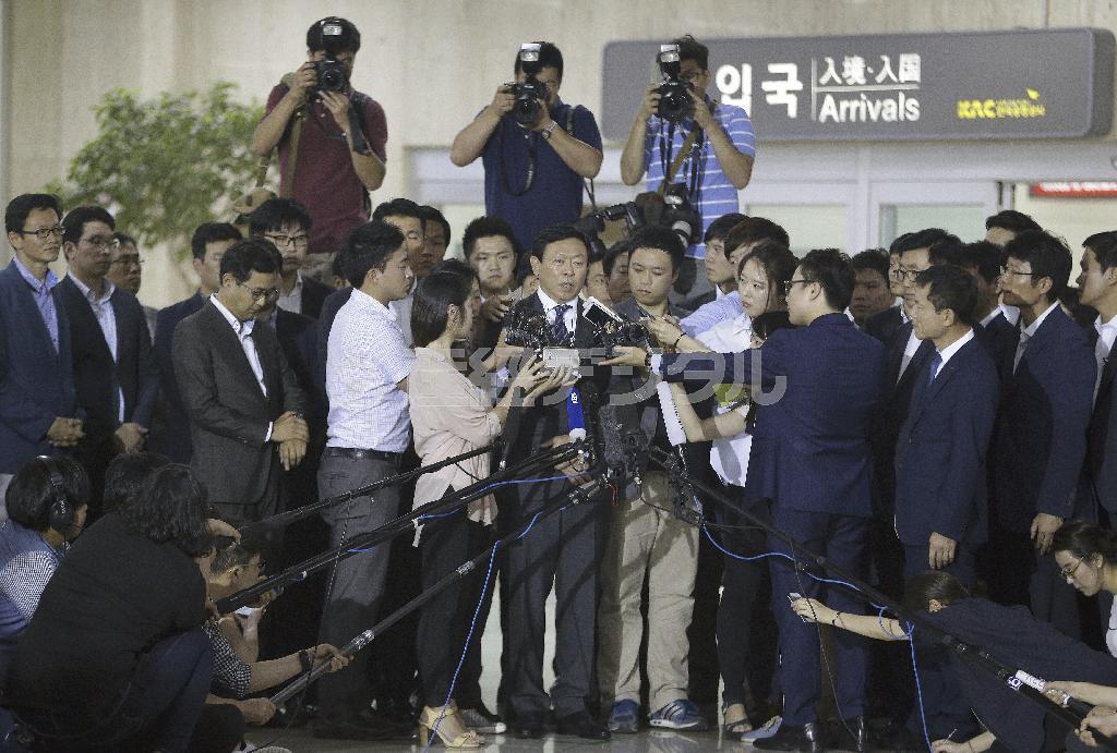 ８月３日、韓国の金浦空港（ソウル）に到着し記者に囲まれる重光武雄氏の次男、昭夫氏（中央）＝２０１５年（ＡＰ）