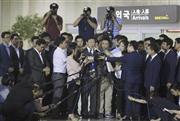 ８月３日、韓国の金浦空港（ソウル）に到着し記者に囲まれる重光武雄氏の次男、昭夫氏（中央）＝２０１５年（ＡＰ）