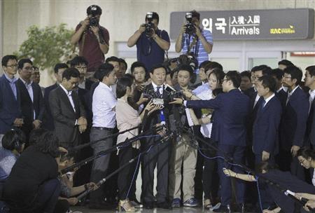 ８月３日、韓国の金浦空港（ソウル）に到着し記者に囲まれる重光武雄氏の次男、昭夫氏（中央）＝２０１５年（ＡＰ）