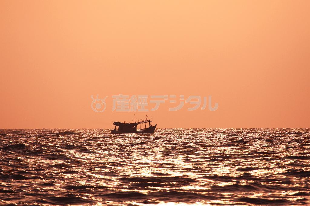 夕陽に染まる海を航海する漁船＝２０１５年６月２７日、ベトナム・フーコック島（佐藤良一さん撮影）