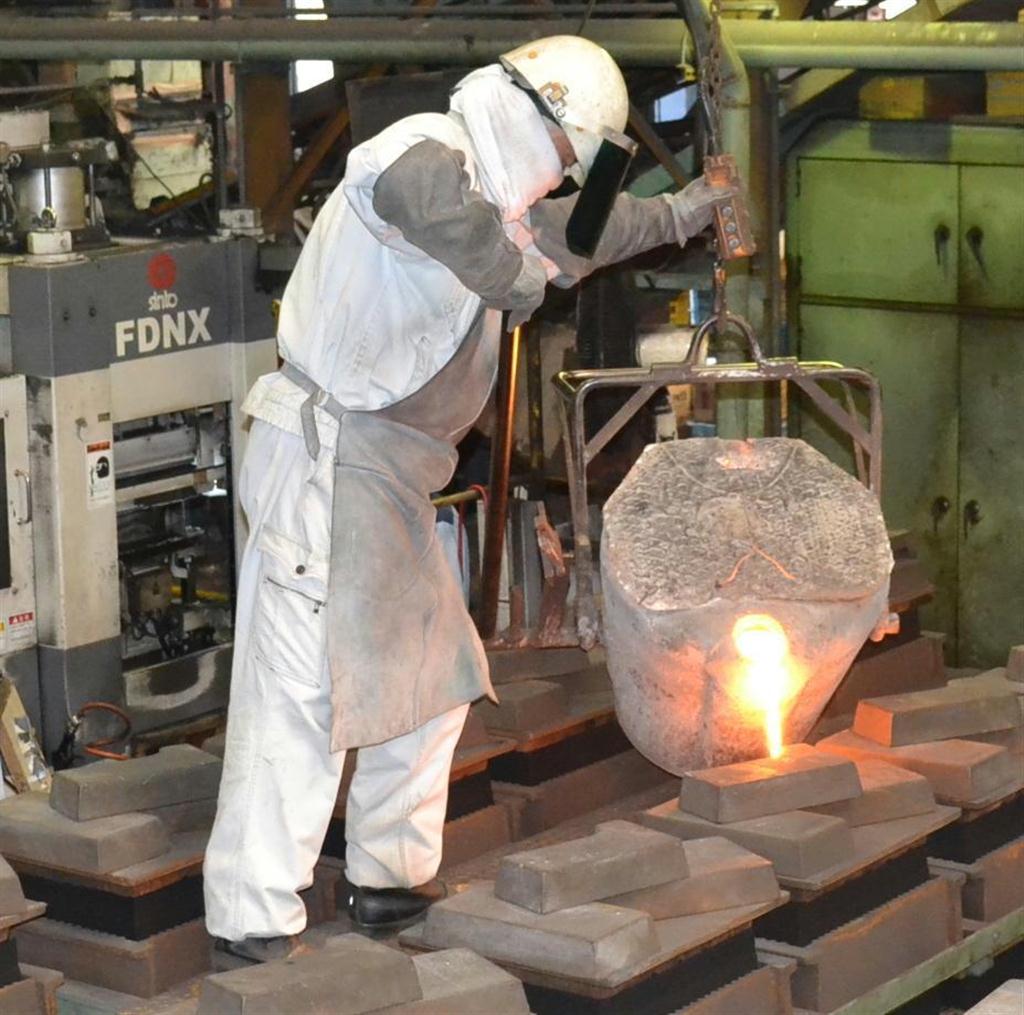 溶けた鉄を鋳型に流し込む楠原製作所の従業員。電気料金の上昇は、経営を圧迫している＝３日午後、福岡県須恵町