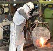 溶けた鉄を鋳型に流し込む楠原製作所の従業員。電気料金の上昇は、経営を圧迫している＝３日午後、福岡県須恵町