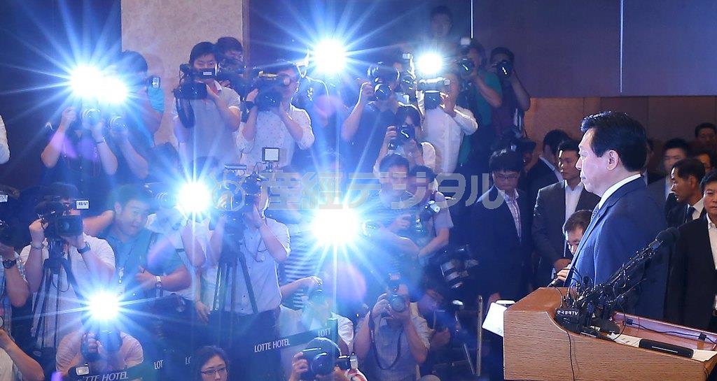 ロッテグループお家騒動の会見場でたくさんのフラッシュを浴びる重光昭夫副会長（右）＝２０１５年８月１１日、韓国・首都ソウル市内（ロイター）