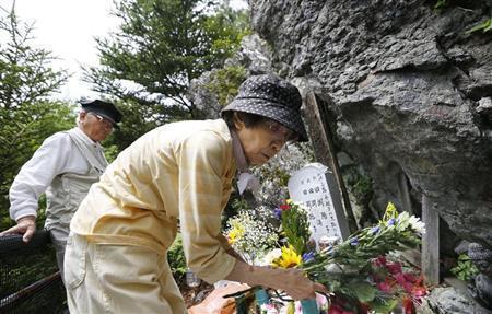 「御巣鷹（おすたか）の尾根」の墓標に花を供える、娘３人を亡くした田淵親吾さん（左）と妻の輝子さん＝２０１５年８月１２日午前、群馬県多野郡上野村（共同）
