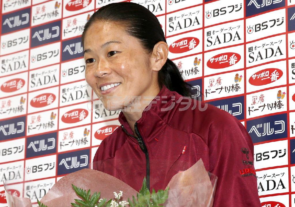 会見で、報道陣から花束を受け取るサッカー女子日本代表の澤穂希（さわ・ほまれ）選手＝２０１５年８月１２日、兵庫県神戸市（鳥越瑞絵撮影）