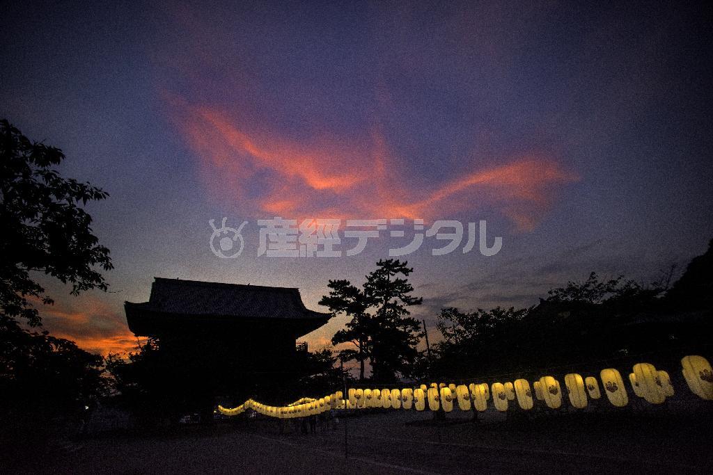 山門上空には夕焼け雲。一足先に訪れた地上の闇を提灯が照らす＝２０１５年７月２６日、神奈川県鎌倉市材木座の光明寺（渡辺照明撮影）