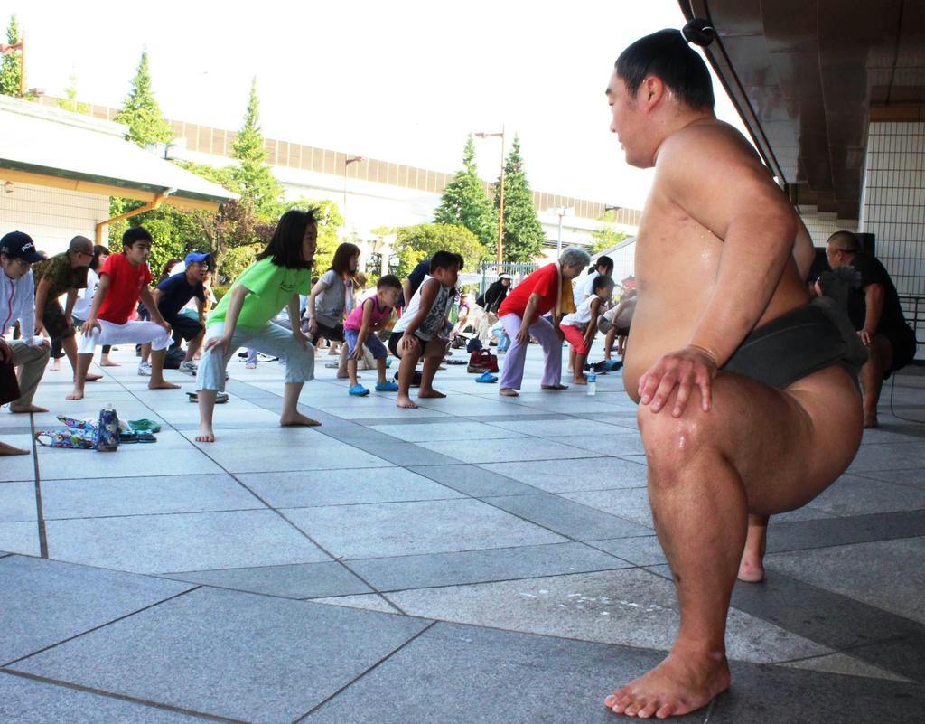 力士の動きをまね、相撲健康体操に取り組む参加者たち。女性の姿も目立った＝東京都墨田区