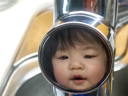 あまりにも娘がいたずらが過ぎるので、台所の水栓に閉じ込めました…。というのは嘘です。娘の手を洗わせようと、鏡面のような蛇口の押しボタンに顔が写っていたのです。面白いなと思い、動く娘が蛇口ボタンに映り込むまで待ってパシャリ。我慢比べです。一人は難しいので、パートナーにも手伝ってもらうのも一つの手です＝２０１５年５月４日（野口隆史さん撮影）