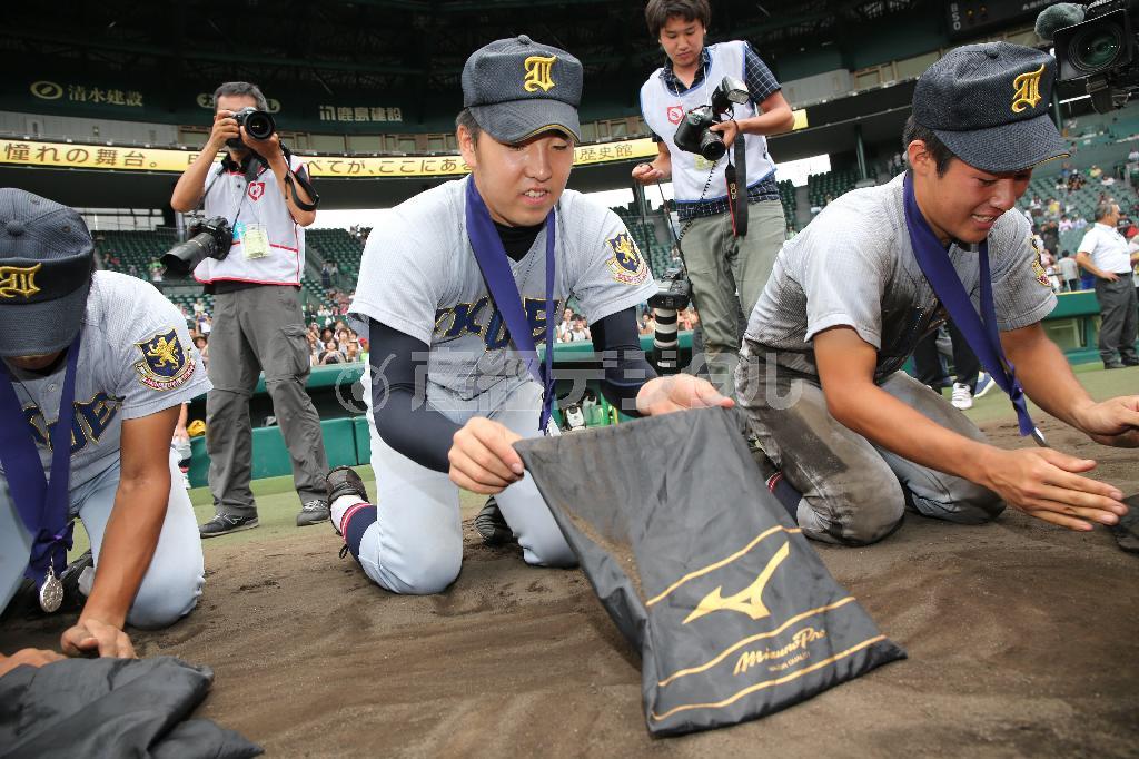 惜しくも決勝で敗れ、甲子園の土をかき集める仙台育英のエース、佐藤世那（せな、中央）＝２０１５年８月２０日、兵庫県西宮市・甲子園球場（福島範和撮影）