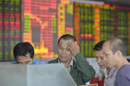 ２１日、中国海南省海口市の証券会社で株価の動きを見る個人投資家ら（共同）