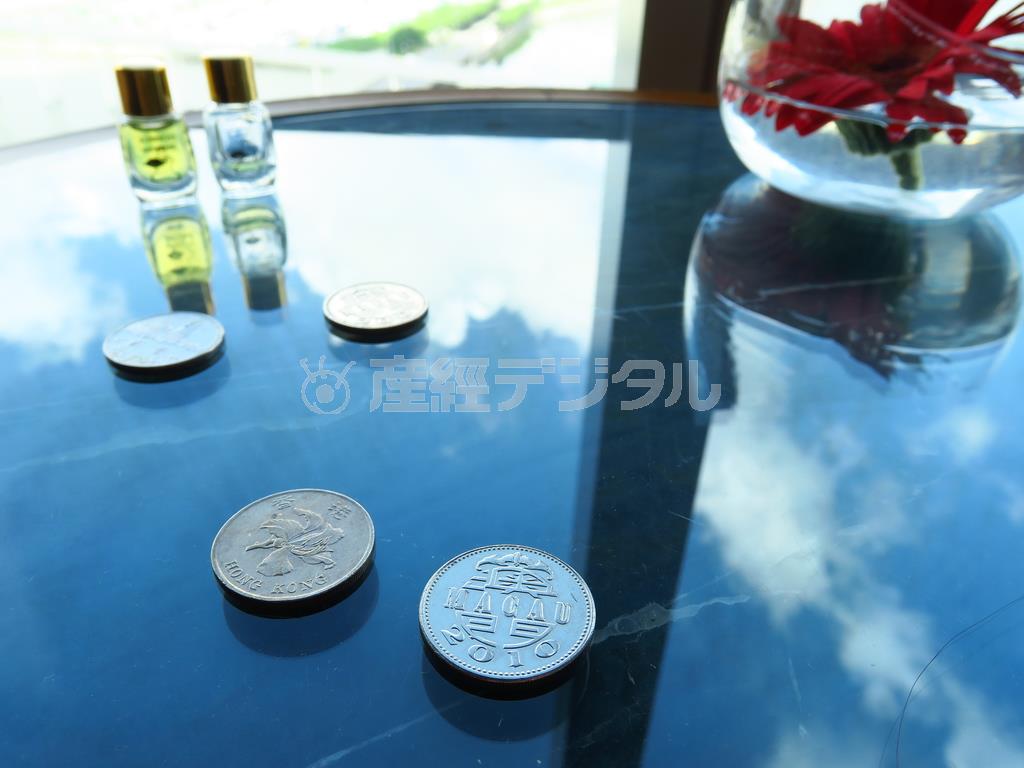 ホテルのサイドテーブルが光沢のある黒っぽいテーブルで、場所によっては雲が写り込むので、少し移動させ、マカオの硬貨を置いて撮影。１枚の写真で、マカオにいること、晴れていることの２つの情報を表現できました＝２０１５年６月２７日、中国・マカオ（須藤夕子さん撮影）