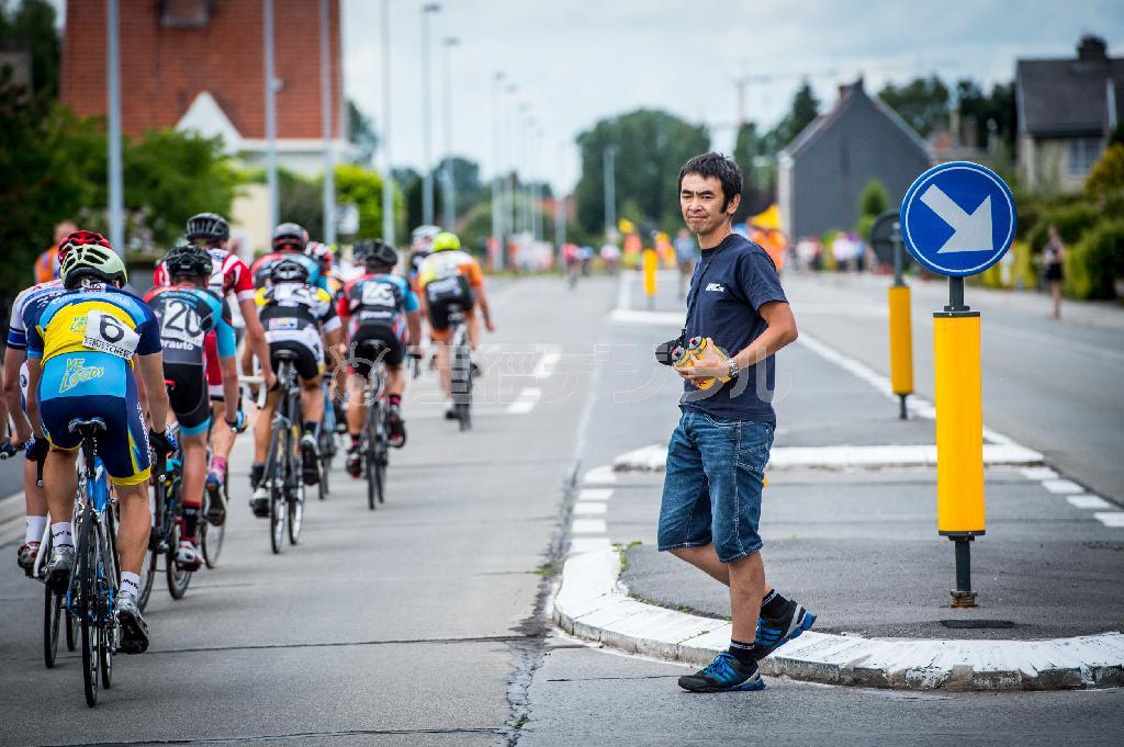 レース中に補給を行う橋川健氏。２０１０年にチームユーラシアを立ち上げ、監督として日本の若手選手を本場の環境で育てている＝２０１５年７月、ベルギー（田中苑子さん撮影）