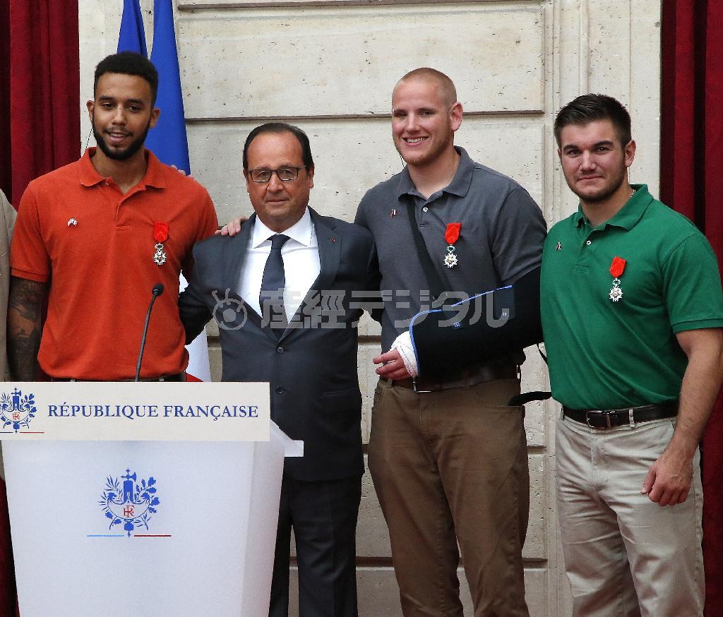 勲章を授与された後、記念撮影に応じるアレックス・スカラトス氏、スペンサー・ストーン氏、オランド大統領、アンソニー・サドラー氏（右から）＝２０１５年８月２４日、フランス・首都パリの大統領府（ＡＰ）