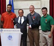 勲章を授与された後、記念撮影に応じるアレックス・スカラトス氏、スペンサー・ストーン氏、オランド大統領、アンソニー・サドラー氏（右から）＝２０１５年８月２４日、フランス・首都パリの大統領府（ＡＰ）