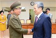 高官会談を終え、握手する北朝鮮の黄炳瑞・朝鮮人民軍総政治局長（左）と韓国の金寛鎮・大統領府国家安保室長（右）＝２５日、板門店の韓国側施設「平和の家」（韓国統一省提供・共同）