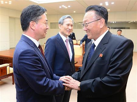高官会談を終え、握手する韓国の洪容杓統一相（左）と北朝鮮の金養建・朝鮮労働党書記。中央は韓国の金寛鎮・大統領府国家安保室長＝２５日、板門店の韓国側施設「平和の家」（韓国統一省提供・共同）