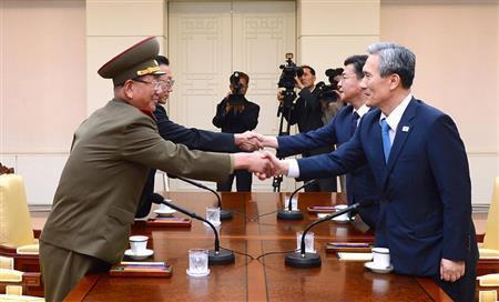 高官会談を終え、握手する北朝鮮の黄炳瑞（ファン・ビョンソ）・朝鮮人民軍総政治局長（左）と韓国の金寛鎮（キム・グァンジン）・大統領府国家安保室長（右）ら＝２０１５年８月２５日、板門店の韓国側施設「平和の家」（ＡＰ）
