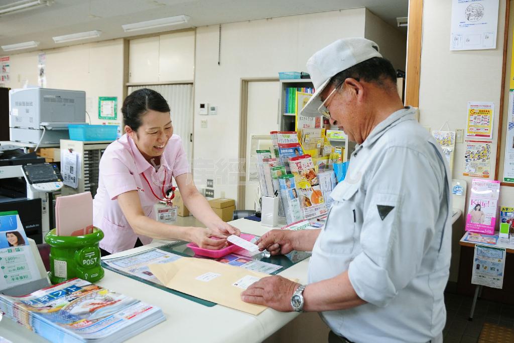 村で唯一の金融機関の平谷郵便局を利用する男性＝７月２８日、長野県下伊那郡平谷村（共同）