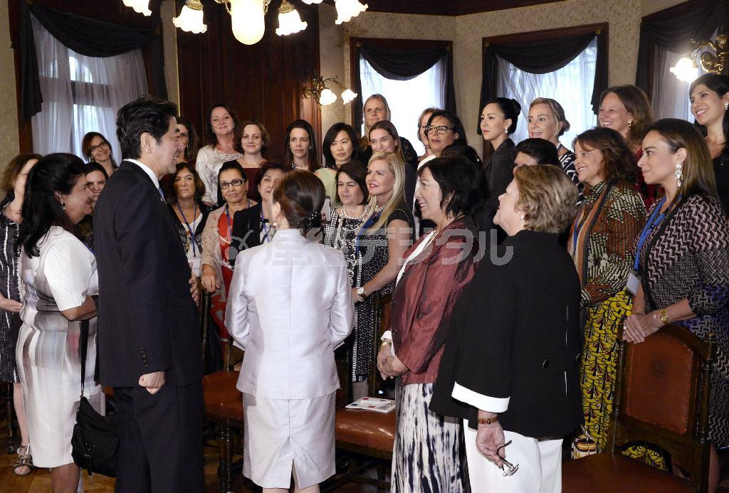 女性が輝く社会に向けた国際シンポジウムで参加者と談笑する安倍晋三（しんぞう）首相（手前左から２人目）＝２０１５年８月２９日、東京都内のホテル（代表撮影）