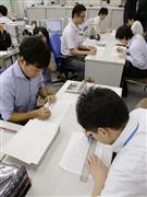 ２０１６年度予算編成に向け、農水省の担当者（右側）から概算要求データを受け取り、確認作業をする財務省の担当者＝３１日午後、財務省