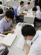 ２０１６年度予算編成に向け、農水省の担当者（右側）から概算要求データを受け取り、確認作業をする財務省の担当者＝２０１５年８月３１日午後、財務省（共同）