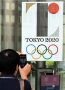 東京都庁の玄関に貼られている２０２０年東京五輪のエンブレムのポスターを撮影する人＝１日午後、東京都新宿区（鴨川一也撮影）