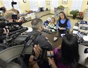 キム・デービス書記官（奥右側）に結婚許可証を発行するよう詰め寄る同性カップルのデビッド・ムーア氏（中央）＝２０１５年９月１日、米ケンタッキー州ローワン郡庁舎（ＡＰ）