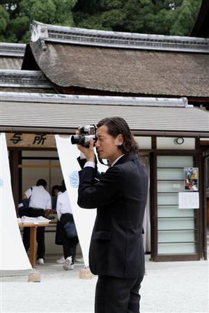 気になる被写体を見つけると、すかさずカメラを構える井浦新（いうら・あらた）さん＝２０１５年６月２０日、京都市左京区の下鴨神社（田中幸美撮影）