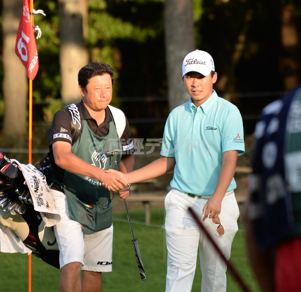 首位と３打差の２位でホールアウトし、キャディと握手する川村昌弘（右）＝２０１５年９月４日、山梨県南都留郡富士河口湖町の富士桜ＣＣ（今野顕撮影）