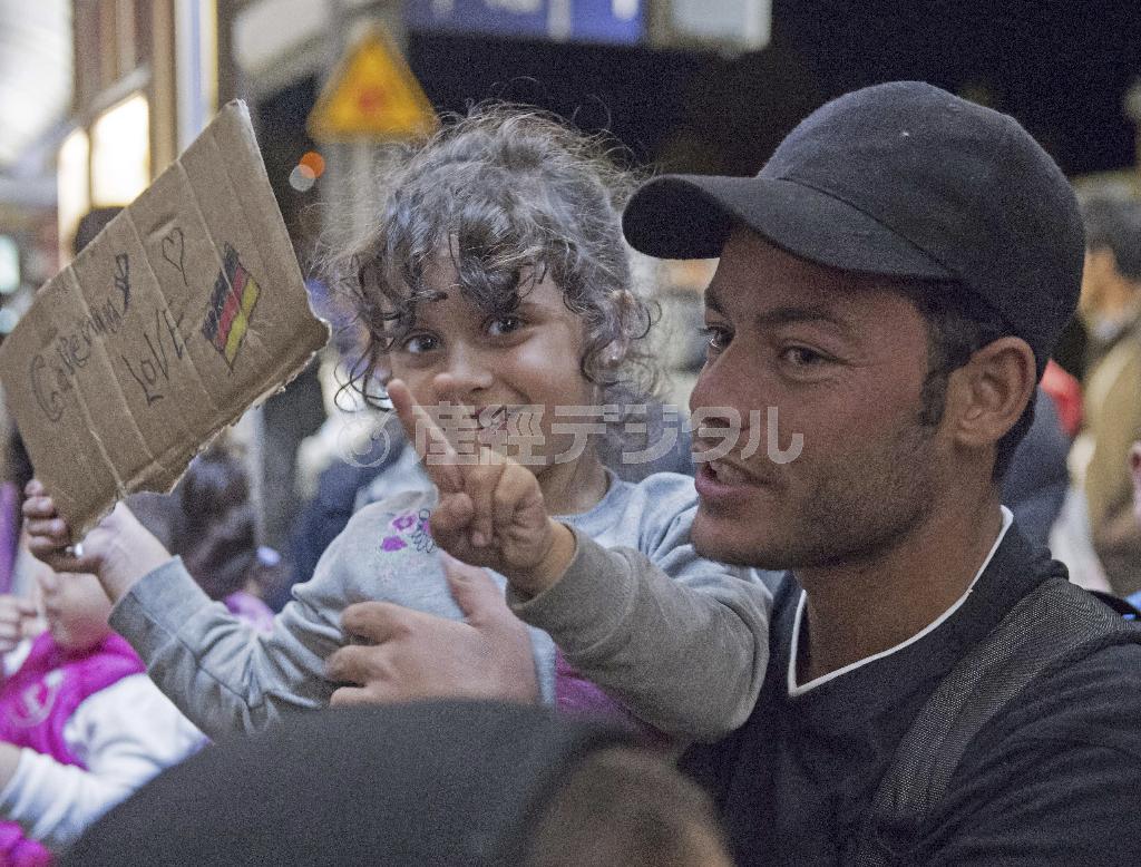 ドイツ南部、バイエルン州ミュンヘンの中央駅に着き、「Ｇｅｒｍａｎｙ＿Ｌｏｖｅ」と書いたメッセージを示す子供＝２０１５年９月５日（ＡＰ）