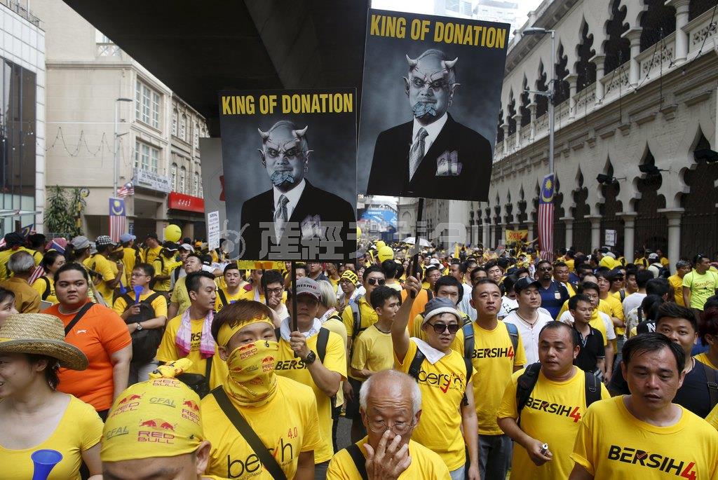 マレーシアの首都クアラルンプールで、ナジブ・ラザク首相の退陣を求めてデモ行進する人々。多くが「Ｂｅｒｓｉｈ（ブルシ＝清潔）」とプリントされた黄色のＴシャツを着込んだ＝２０１５年８月２９日、マレーシア・首都クアラルンプール（ロイター）